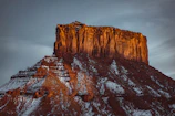 A panoramic view of a mesa at sunset, with warm hues painting the sky.