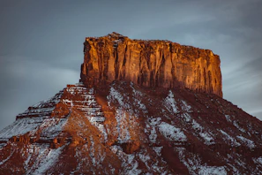 A panoramic view of a mesa at sunset, with warm hues painting the sky.