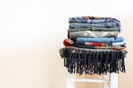 Stacks of freshly woven cloth in various textures and colors.