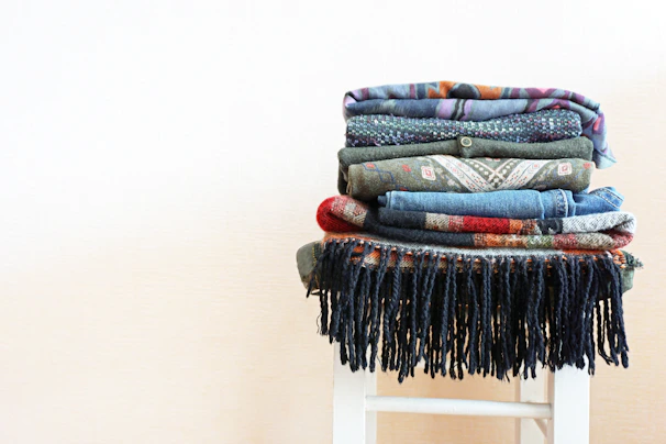 A neatly folded stack of diverse textile samples highlighting texture and craftsmanship.