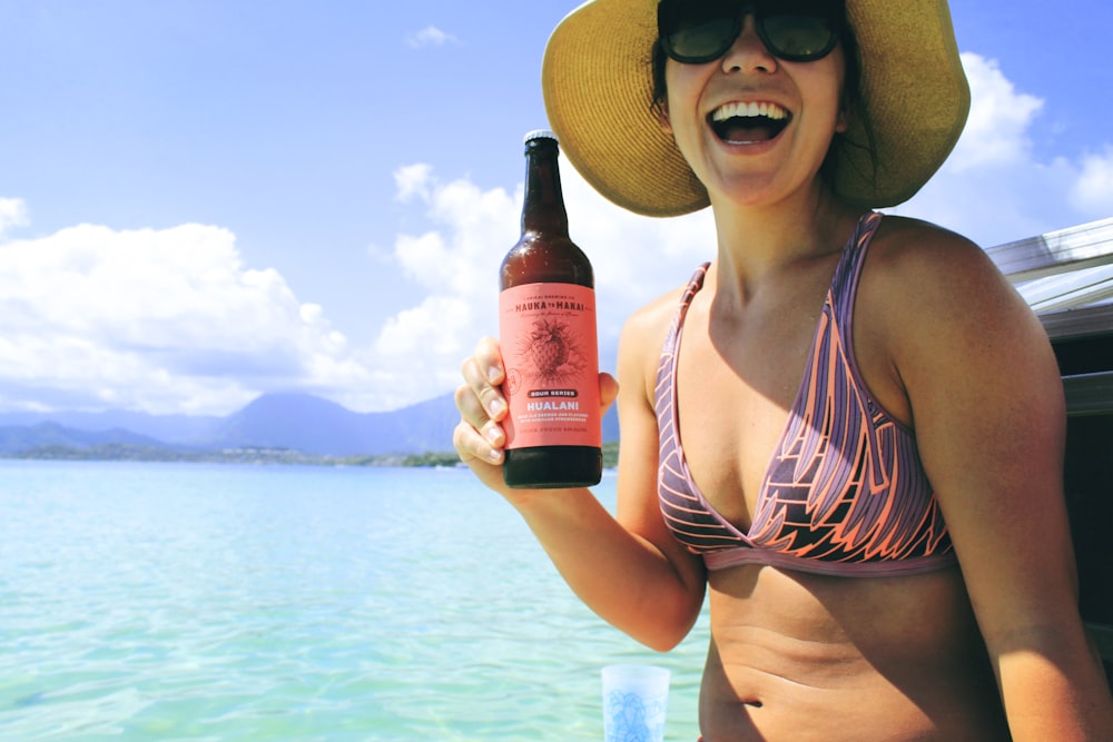 smiling woman holding glass bottle