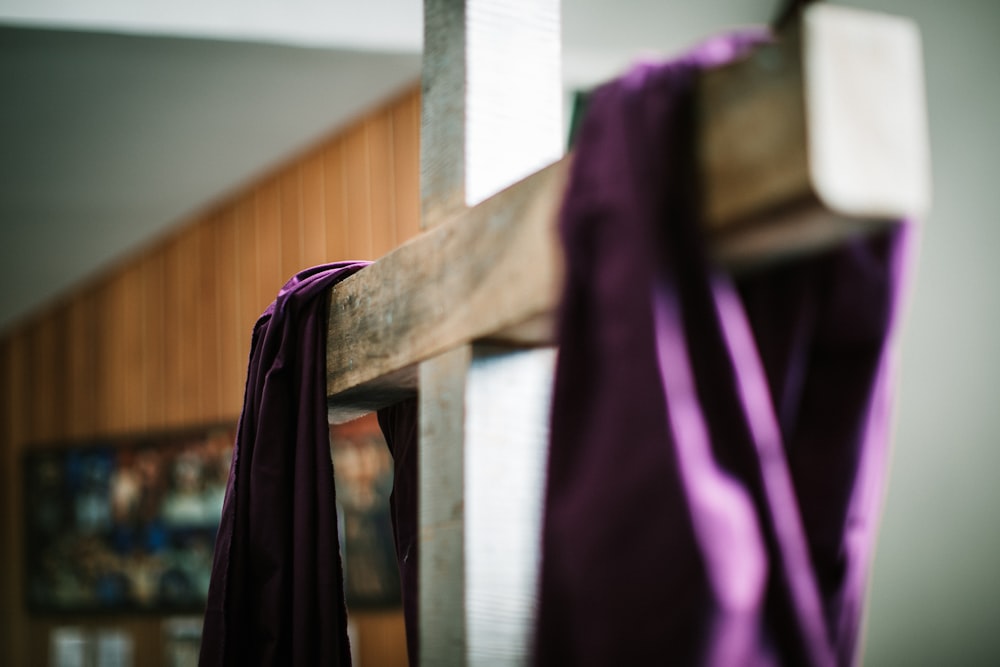 a wooden cross with a purple cloth draped over it