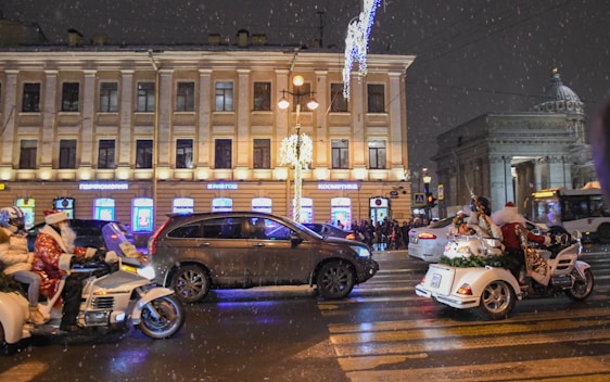 A group of riders dressed in festive red and white gear, smiling as they prepare to start the Christmas Peace Rally under twinkling holiday lights.
