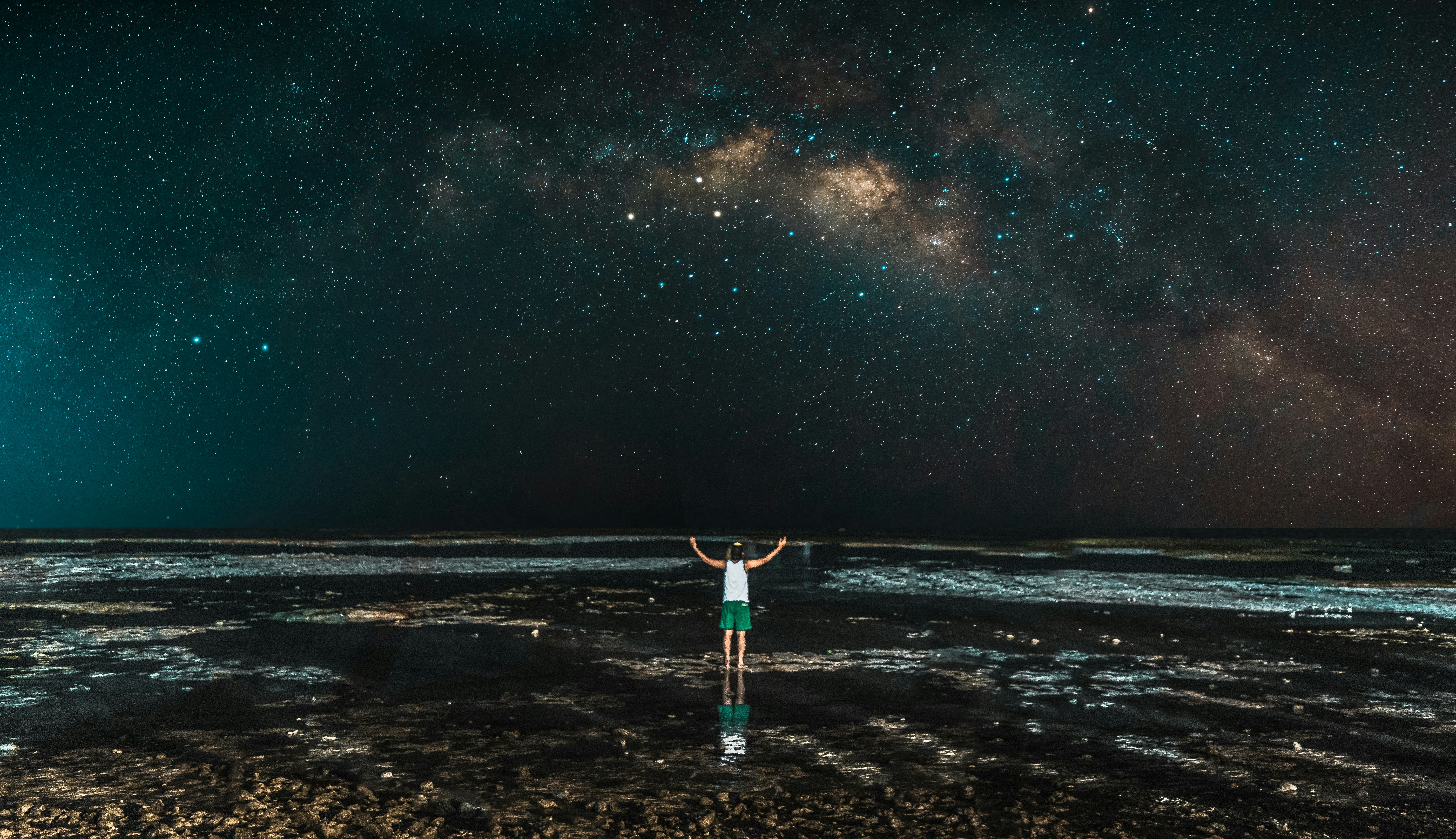 person standing in front of sea during nighttime