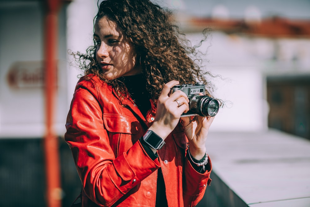 woman holding black DSLR camera