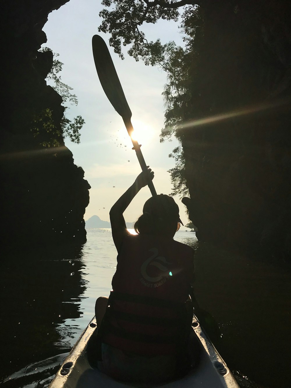 silhouette photography of man holding boat paddle