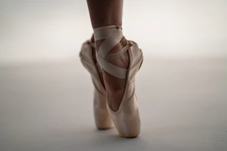 person in white ballet shoes