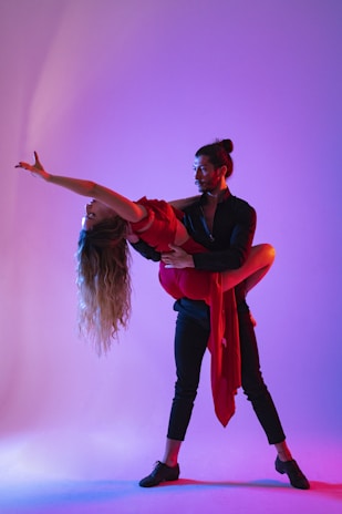 A vibrant wedding dance captured in motion, with colorful lights and joyful expressions.