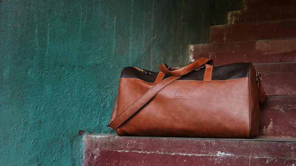 brown Gucci leather duffel bag on brown stair