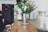 Close-up of a rustic wooden table with a stylish patterned tablecloth and a vase of fresh flowers.