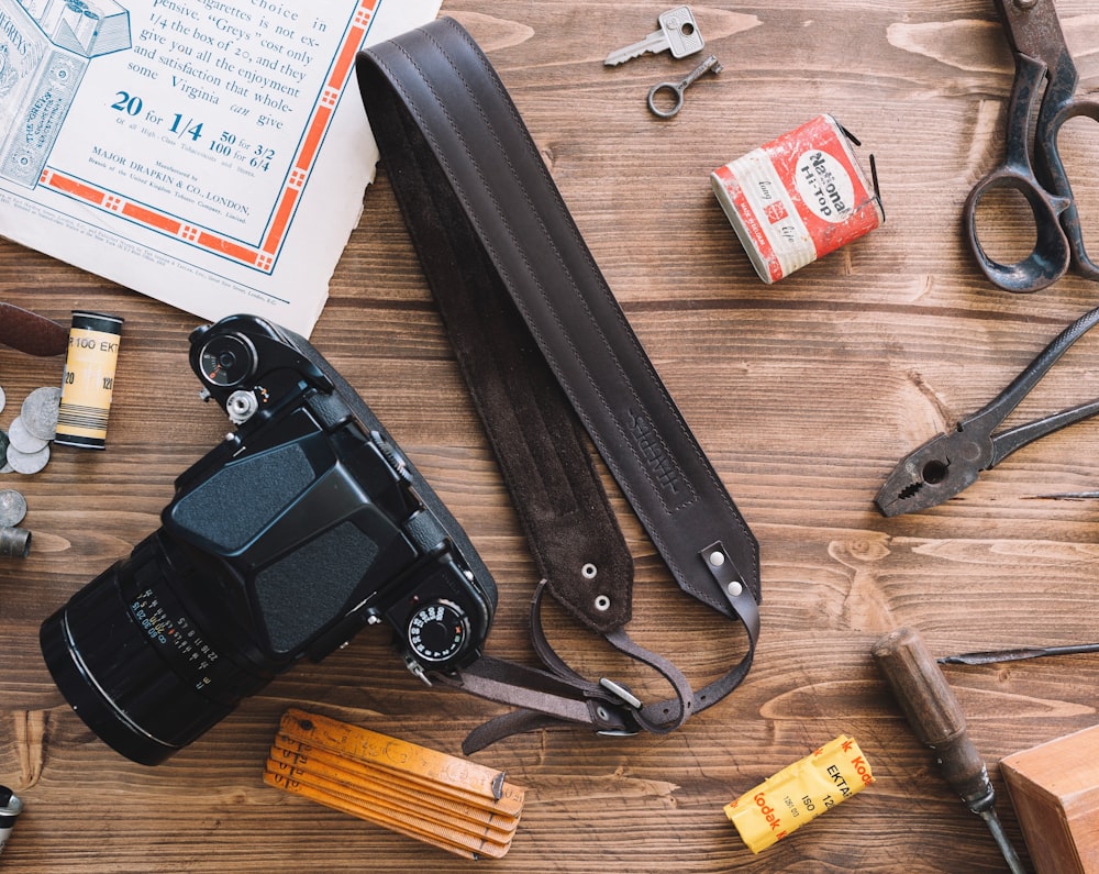 black DSLR camera on brown wooden surface