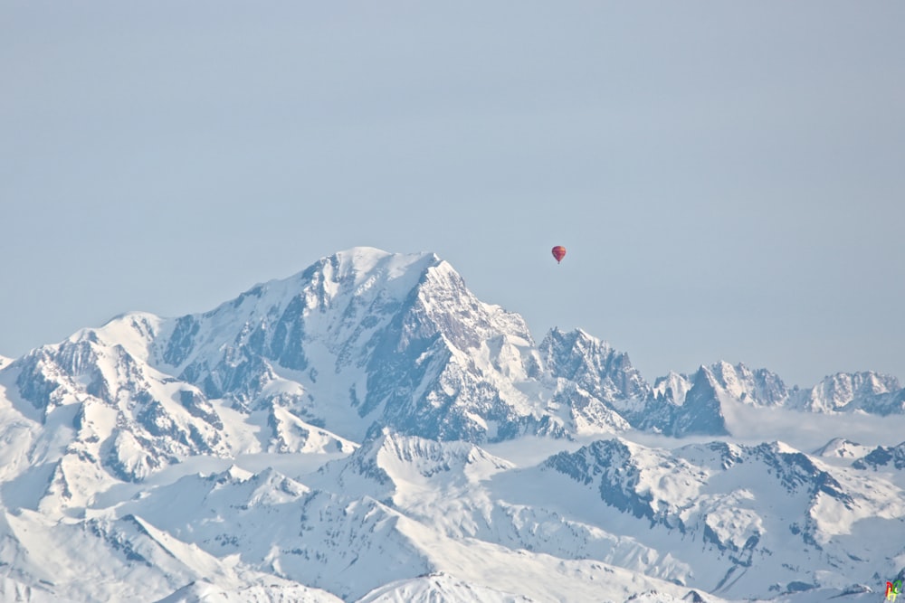 hot air balloon above snow-covered mountain