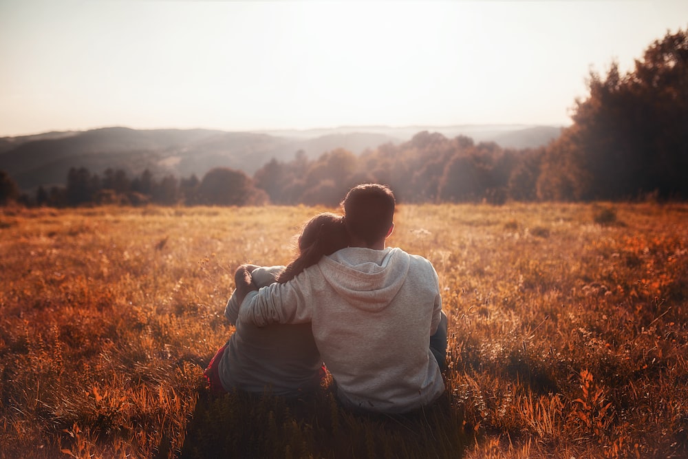 man and woman sitting on grass