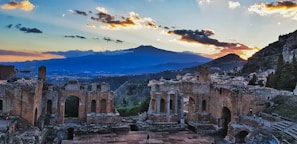 A scenic hotel terrace overlooking the ancient city ruins under a golden evening sky