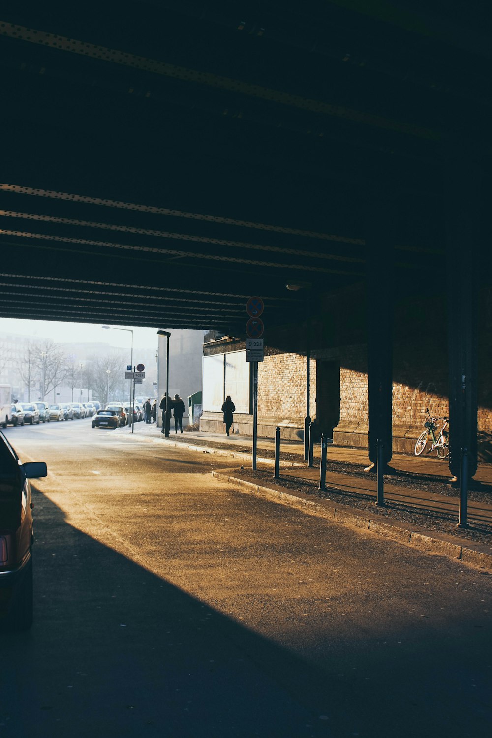 people walking underneath bridge