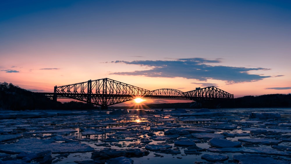 grey metal bridge on river during golden hour