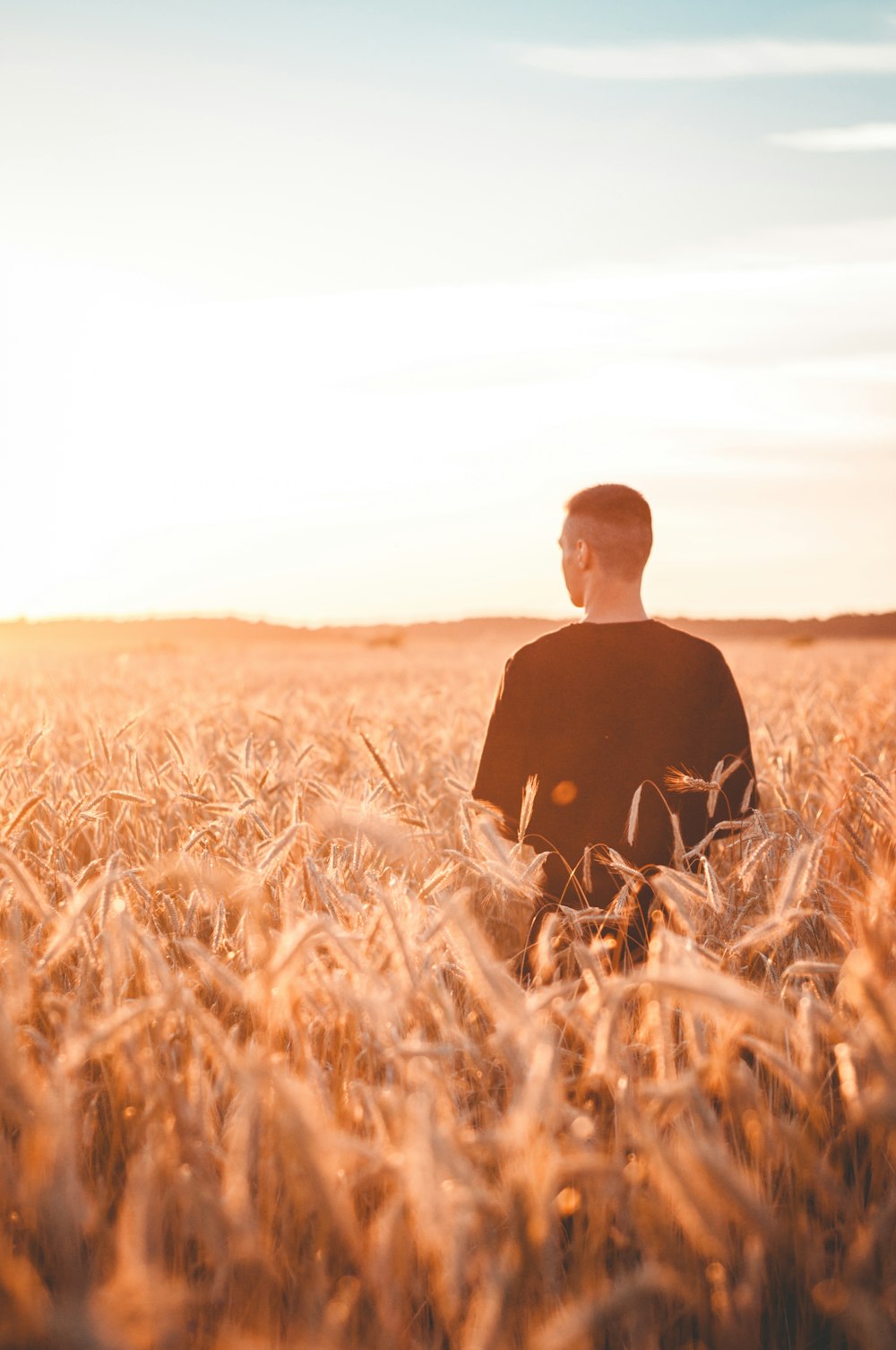 man wearing black shirt standing on grasses