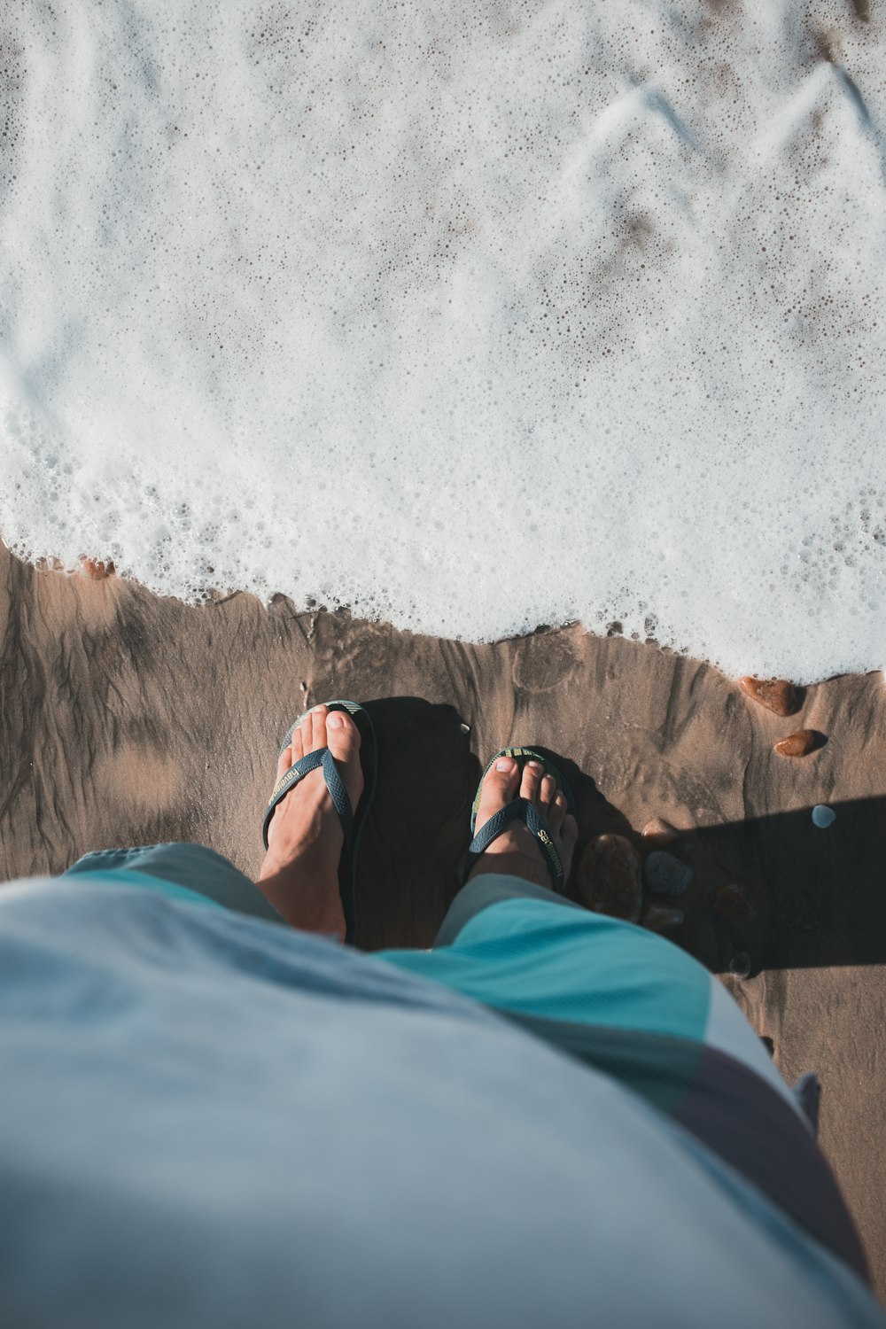 person wearing grey flip-flops