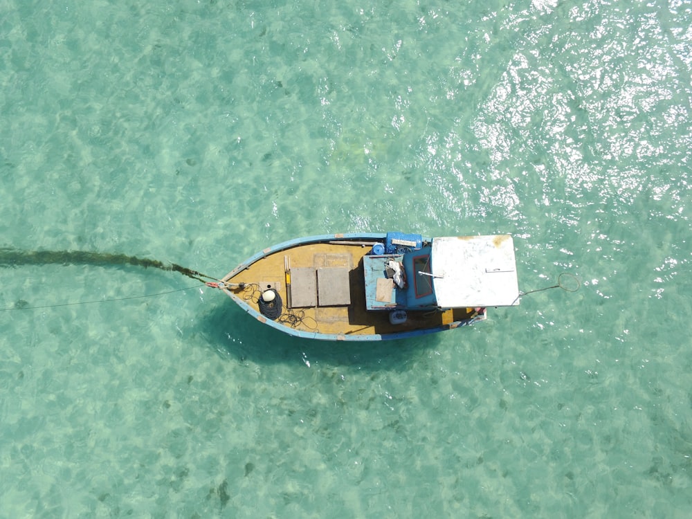 Photographie aérienne bateau bleu et brun sur l’eau