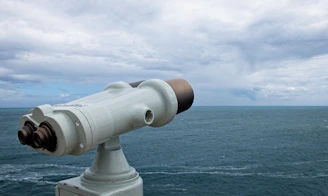 Guardians monitoring the sea from a high vantage point with binoculars and radar equipment.