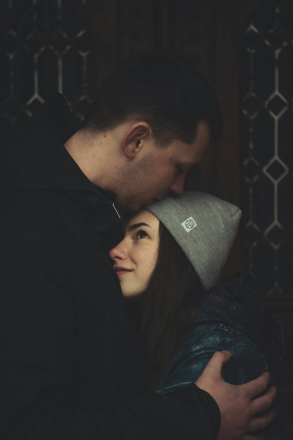 man kissing woman's forehead