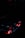 A dark image focusing on a computer component, possibly a graphics card, with glowing red LED lights. The environment is dimly-lit, accentuating the red and subtle highlights from the hardware.