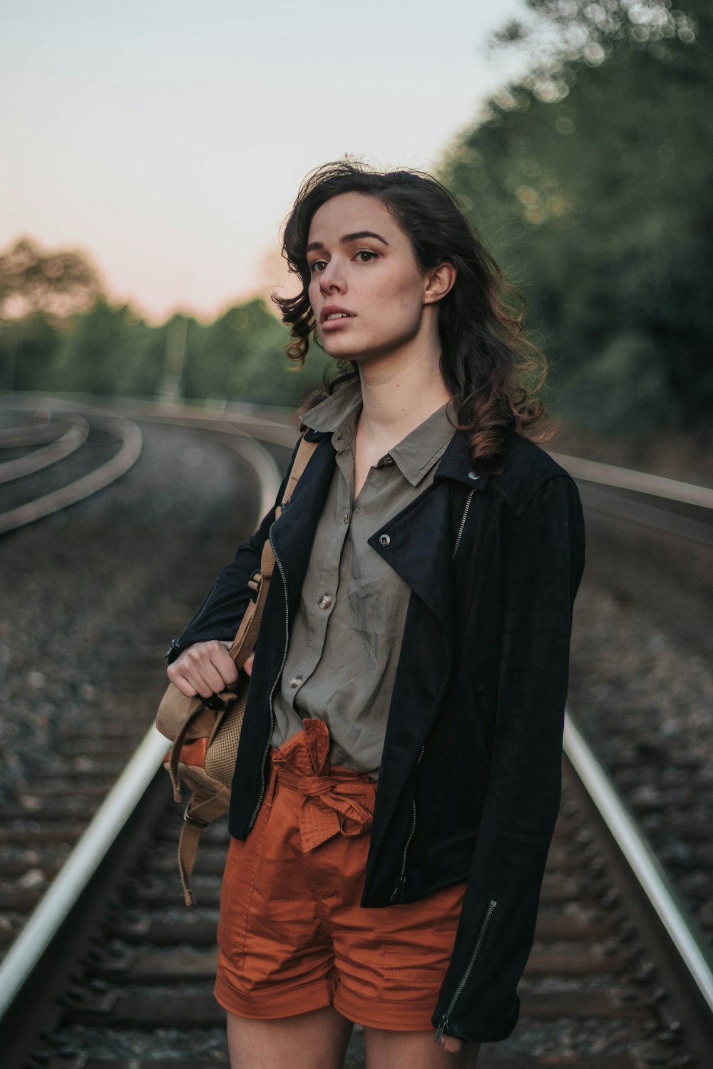 woman standing in the middle of railway