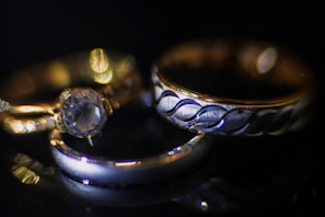 Close-up of sparkling Rommanel rings with the brand logo faintly visible behind