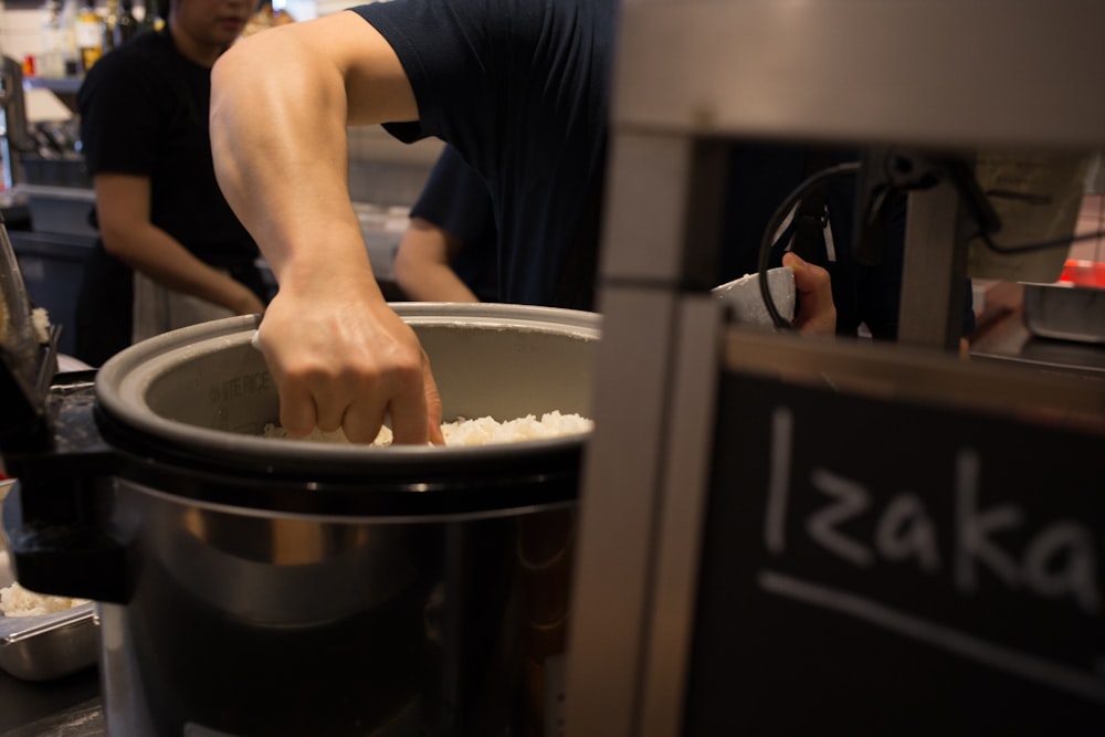 a man putting rice into a large pot