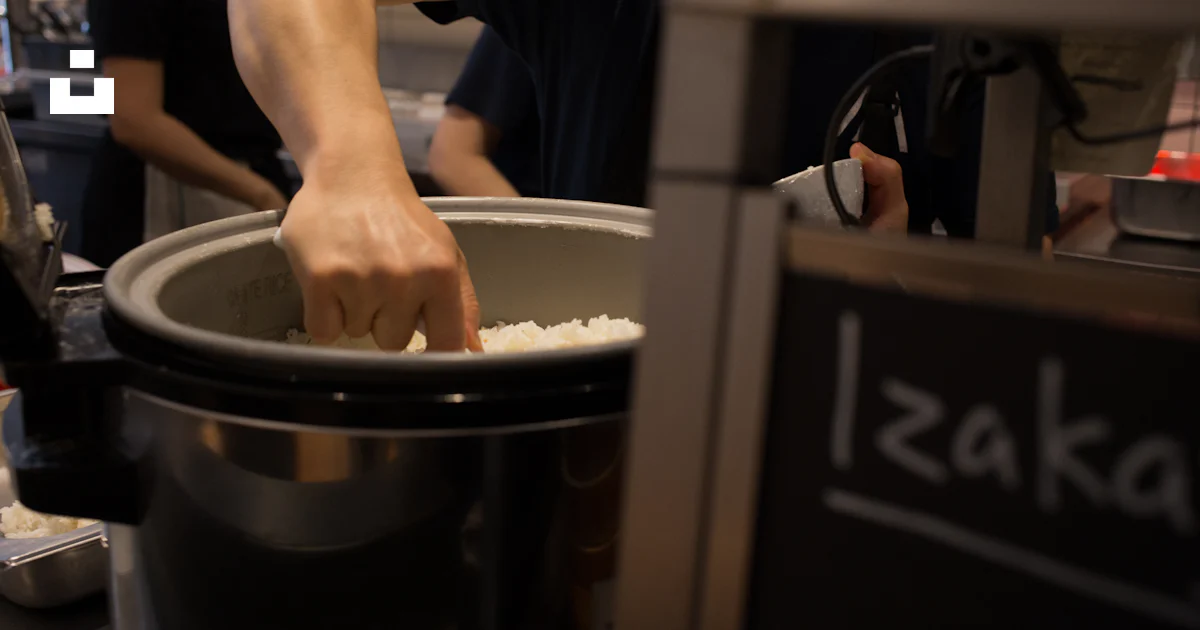 Un homme mettant du riz dans une grande marmite photo – Photo Izakaya ...
