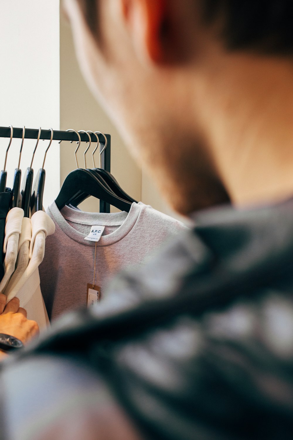 man standing in front of hanging clothes