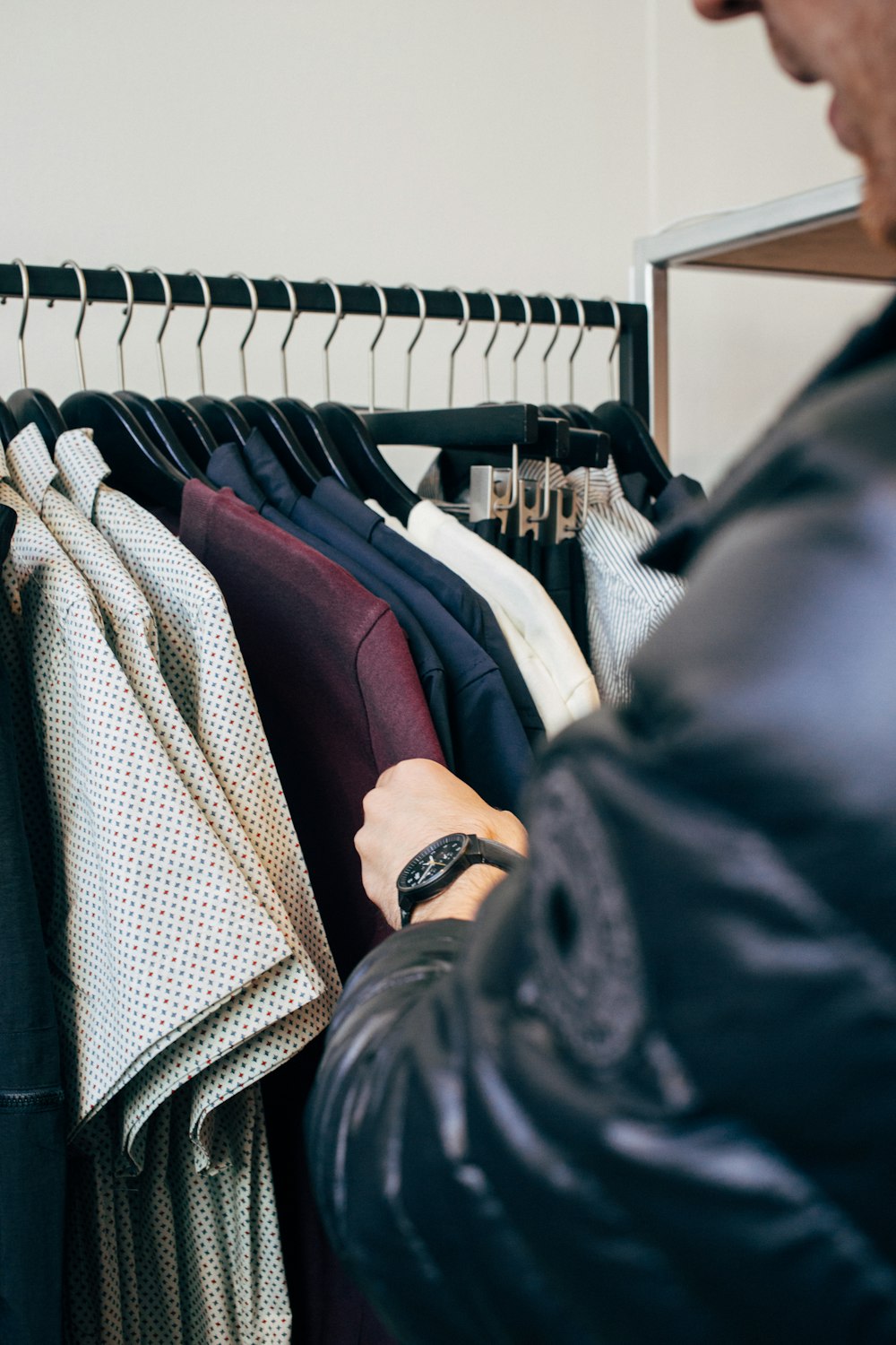 man wearing jacket picking t-shirts