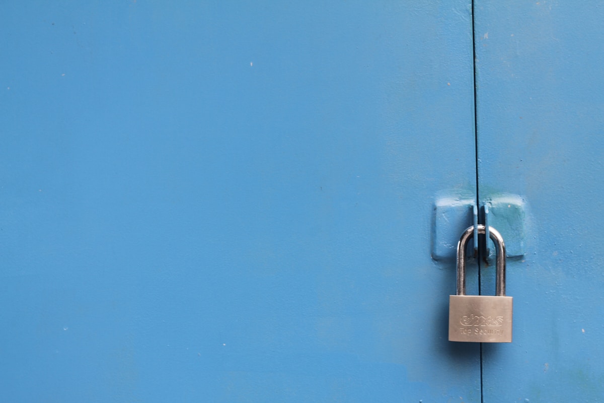Silver padlock on a metal gate symbolizing access control and security