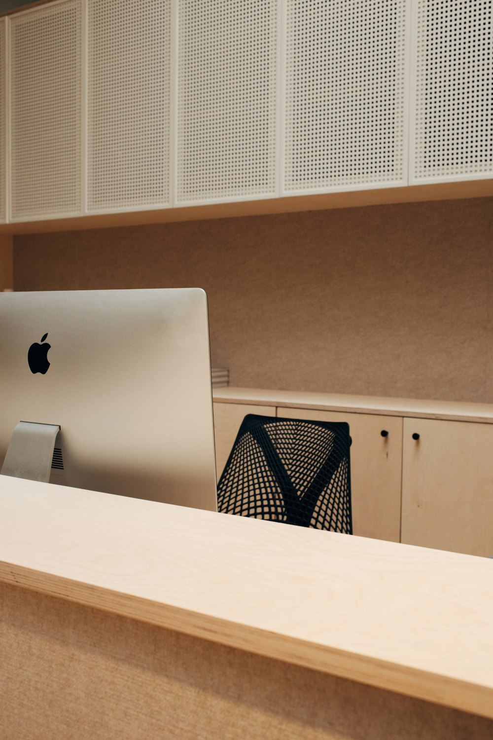 iMac argenté sur surface en bois beige