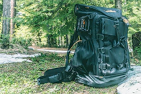 Close-up of a compact, ultralight backpack resting against a forest trail.