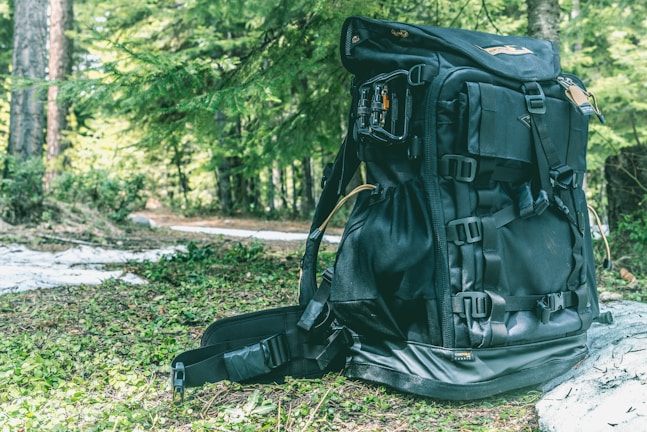 A backpack filled with camping gear against a forest backdrop.