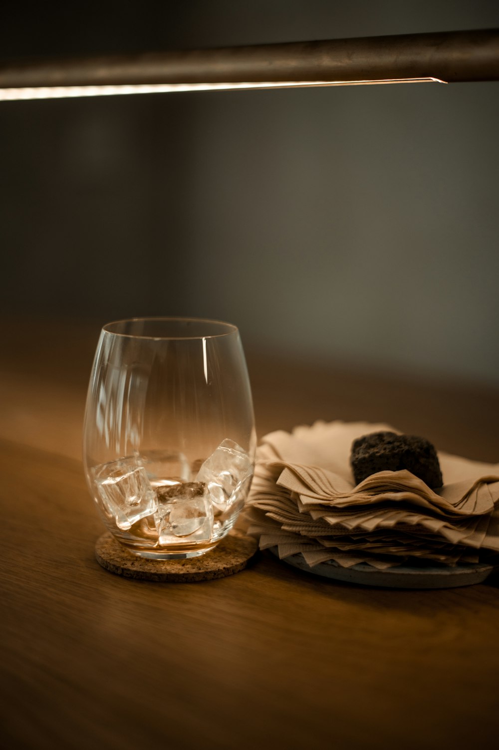 clear drinking glass beside paper