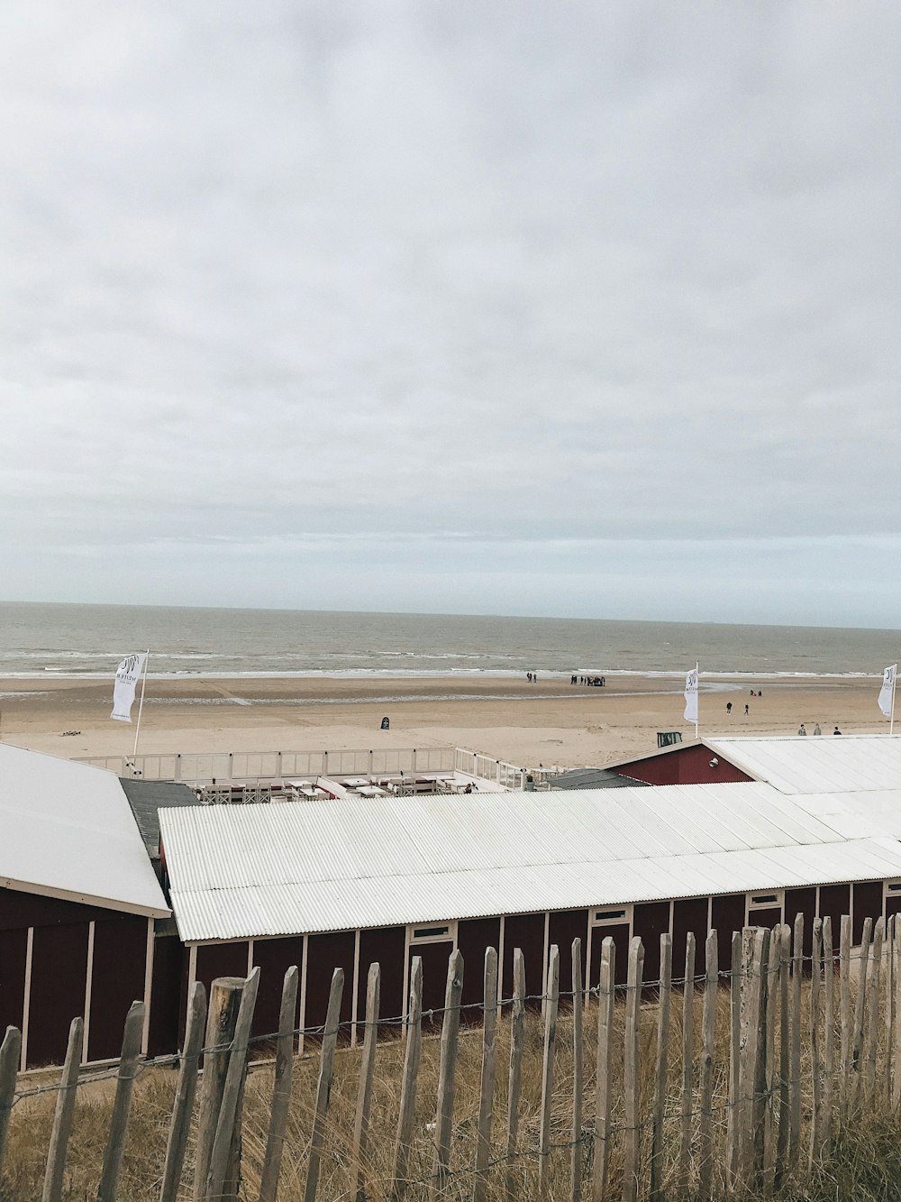 white and brown wooden building near sea during daytime