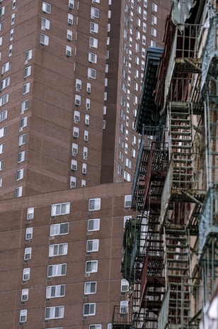 An urban apartment building with fire escapes and rooftop access, showing the character of city living.