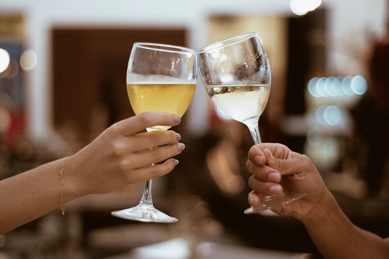 Two hands toasting with glasses of wine