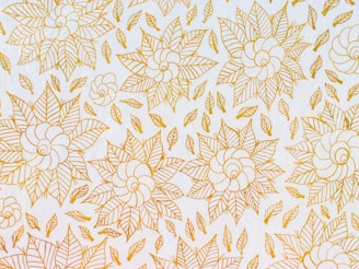 A decorative floral motif painted with delicate brush strokes on a light background.