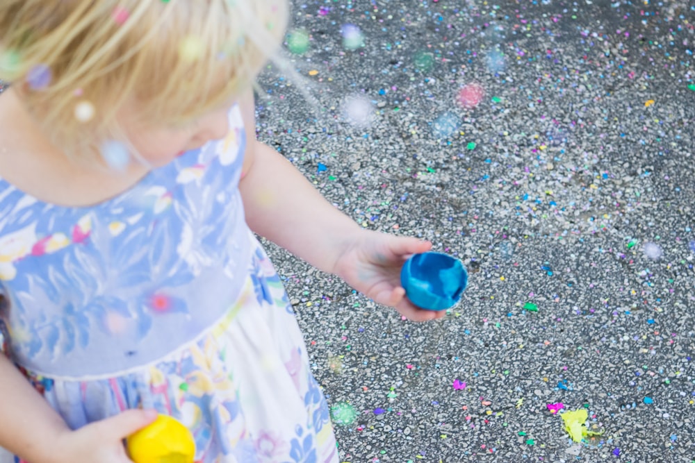 girl holding blue toy