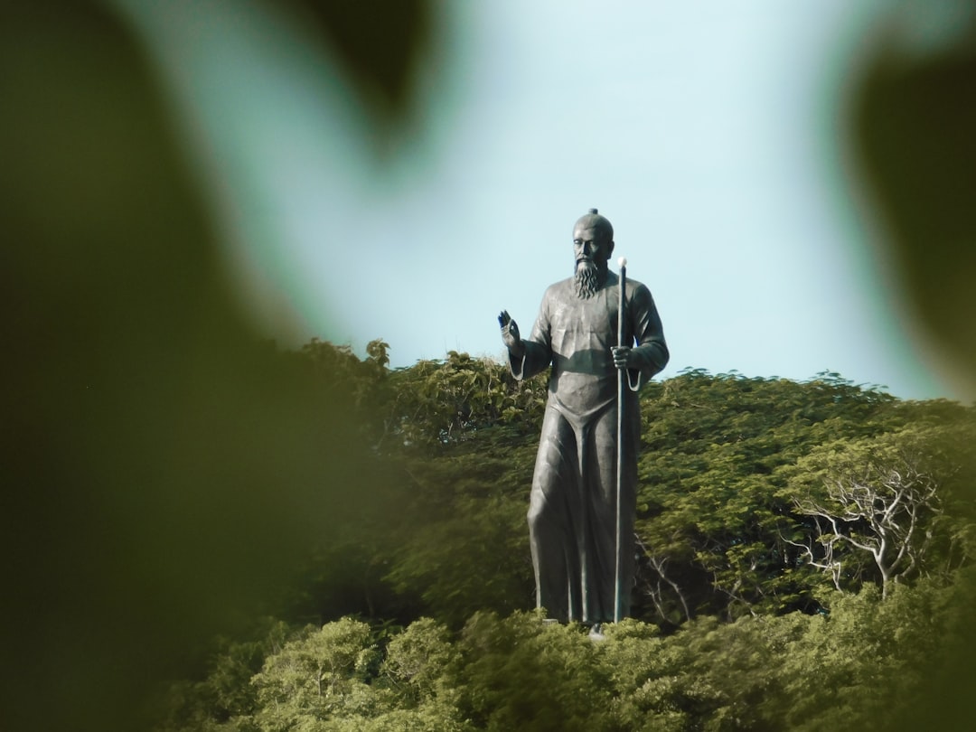 man holding cane statue