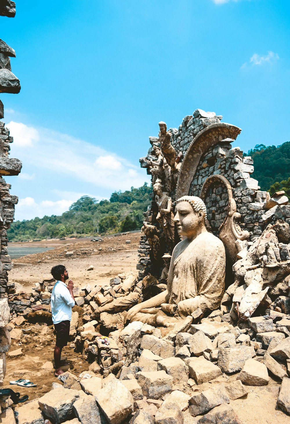 man wearing white shirt in front of statue