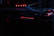 A close-up view of a computer component featuring the logo and lettering 'Republic of Gamers.' The setup is illuminated with red LED lights, and cables are visible connecting the hardware.