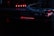 A close-up view of a computer component featuring the logo and lettering 'Republic of Gamers.' The setup is illuminated with red LED lights, and cables are visible connecting the hardware.