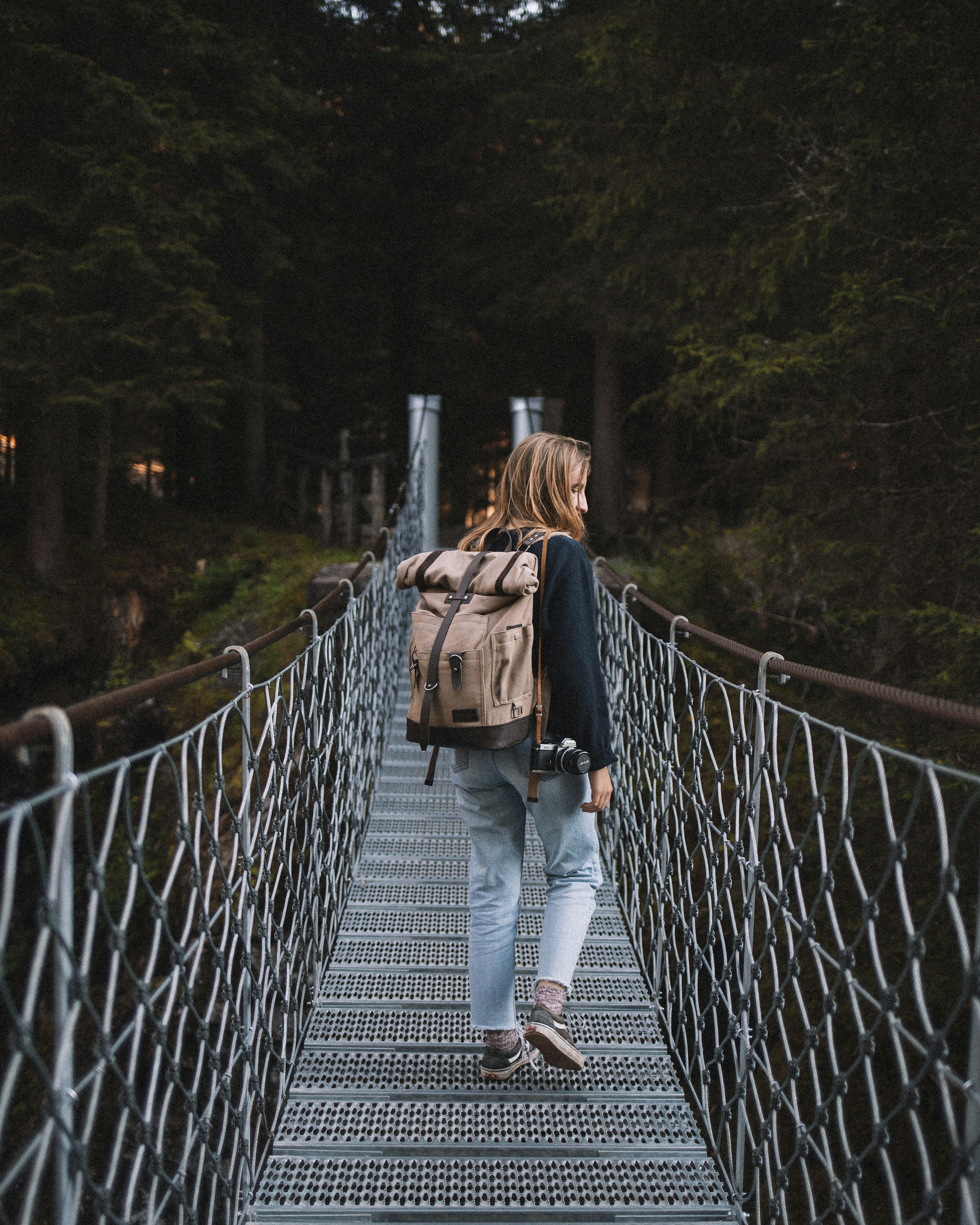 woman standing on gray hanging bridge