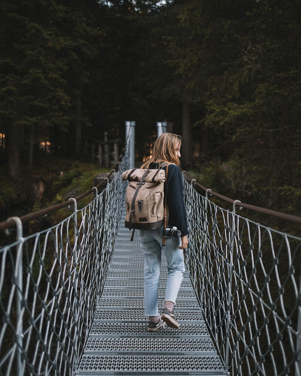 woman standing on gray hanging bridge