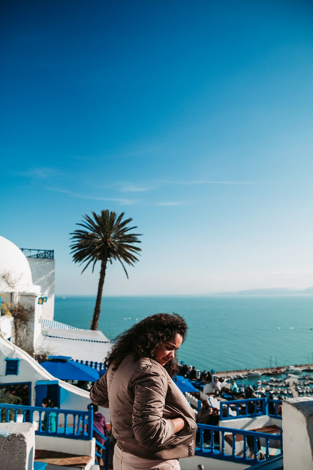 mulher em pé no chão de concreto com vista para o mar