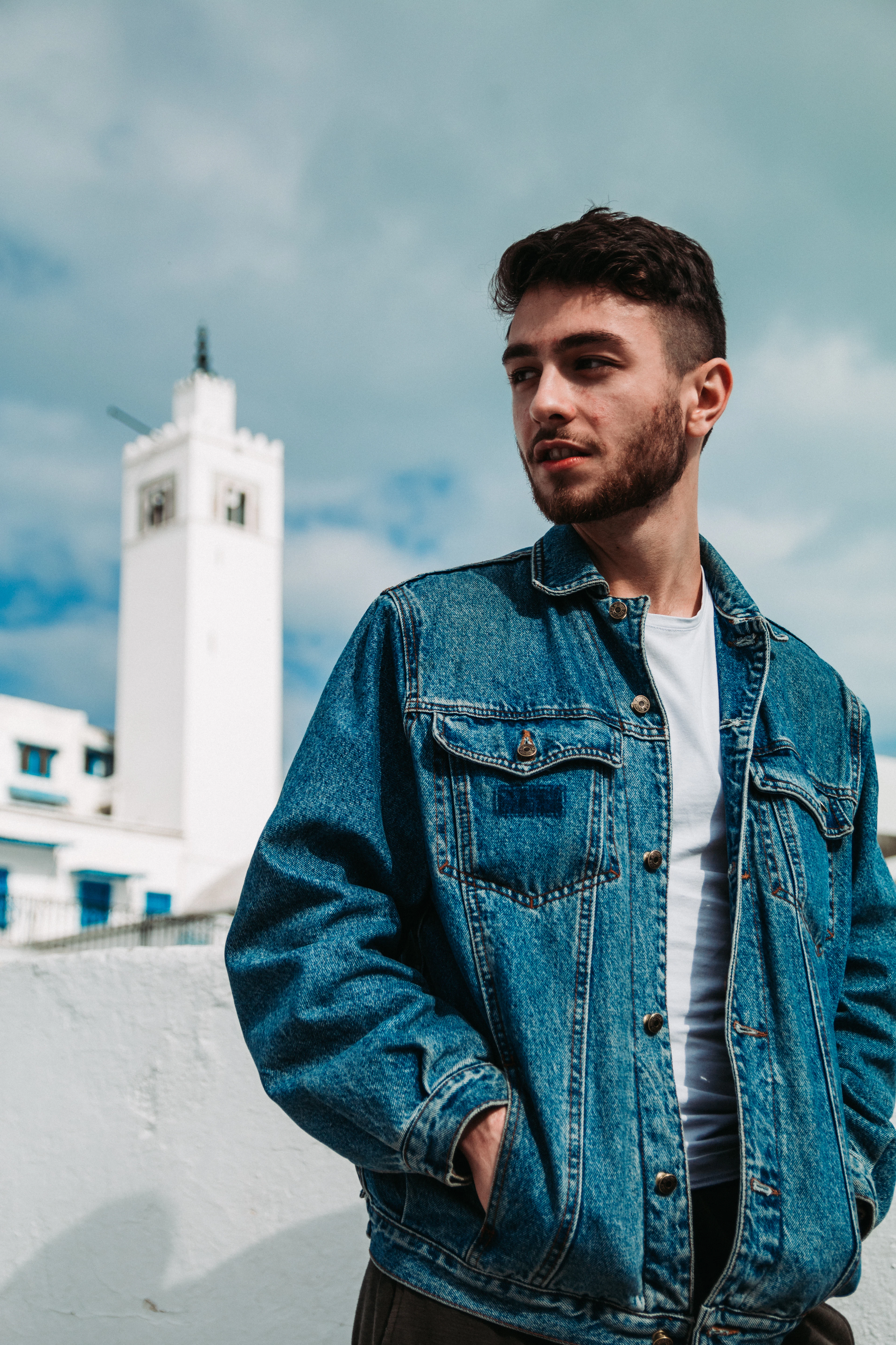 Man in a washed blue denim jacket and white tee